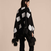 BLACK/WHITE Poncho en cachemire à motif check tissé en jacquard avec pompons en fourrure de raton laveur