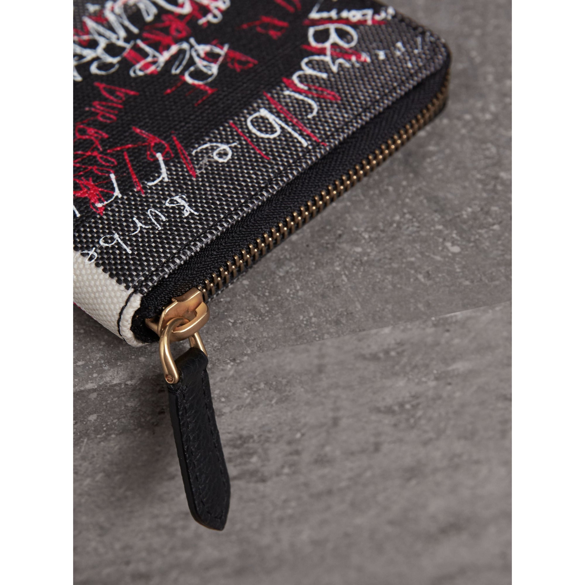 BLACK/BLACK Portefeuille zippé en toile enduite à motif check et imprimé Doodle